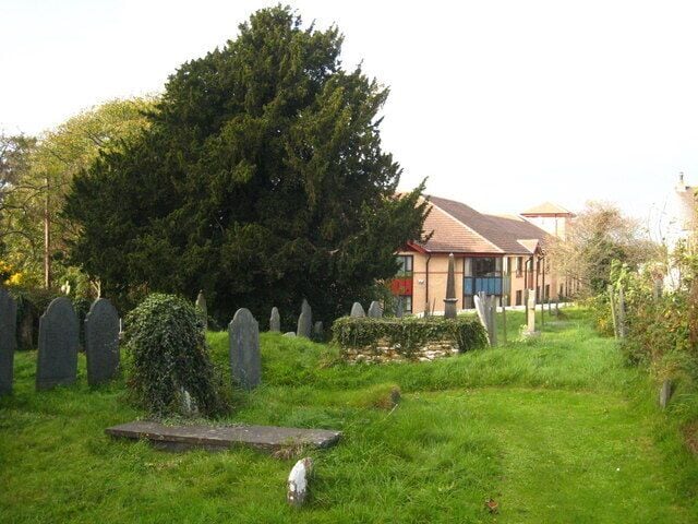 Part of St Mary and All Saints' parish churchyard, Plymstock, Devon, with a yew tree centre left