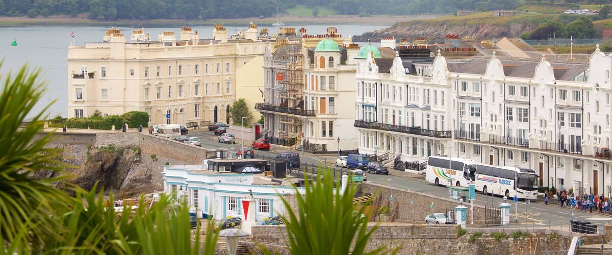 A coastal town with historic buildings, a waterfront, and a bus terminal.
