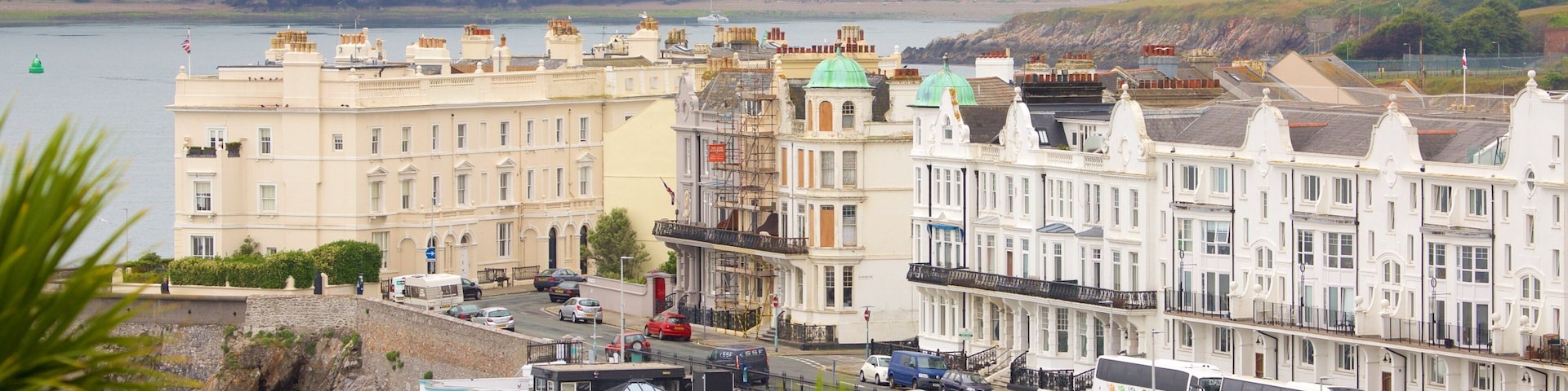 A coastal town with historic buildings, a waterfront, and a bus terminal.