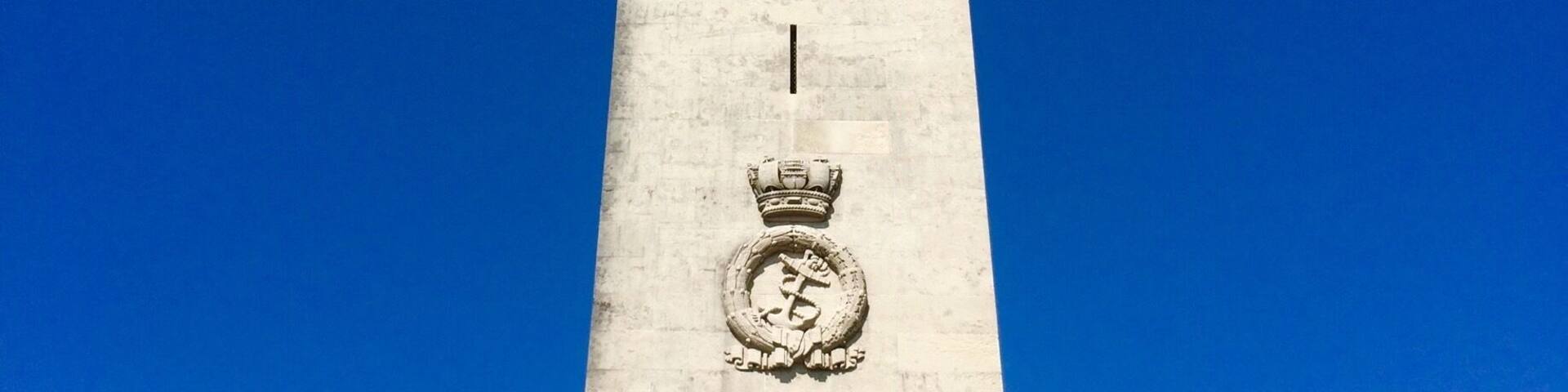 Un monumento alto con una estatua de león en la base y una corona en la parte superior.