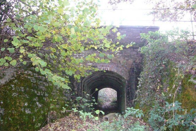 An old stone bridge in a wooded area.