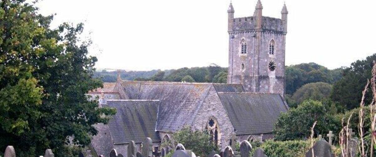 Una iglesia con una torre y un cementerio con lápidas.
