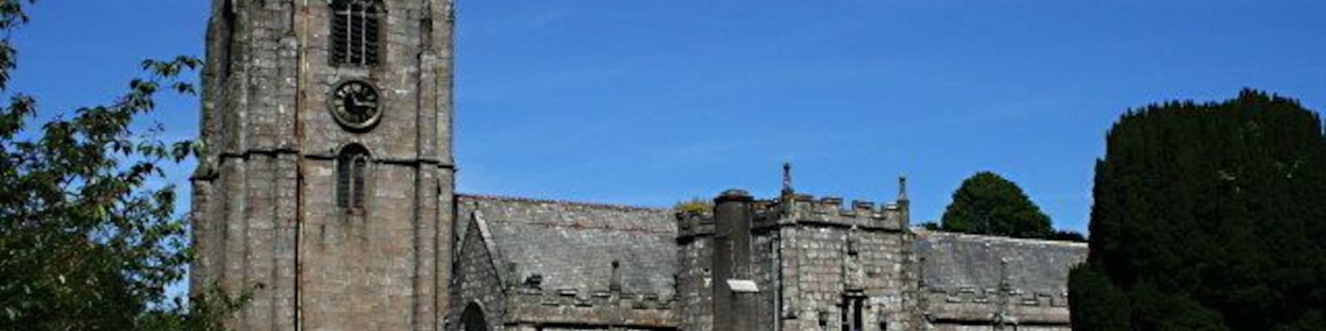 Una iglesia histórica con una torre alta y ventanas de arco.