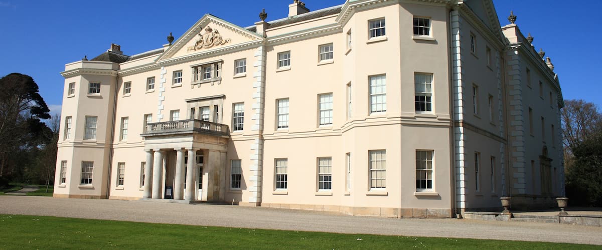 A large, classical building with a symmetrical facade, columns, and a central balcony.