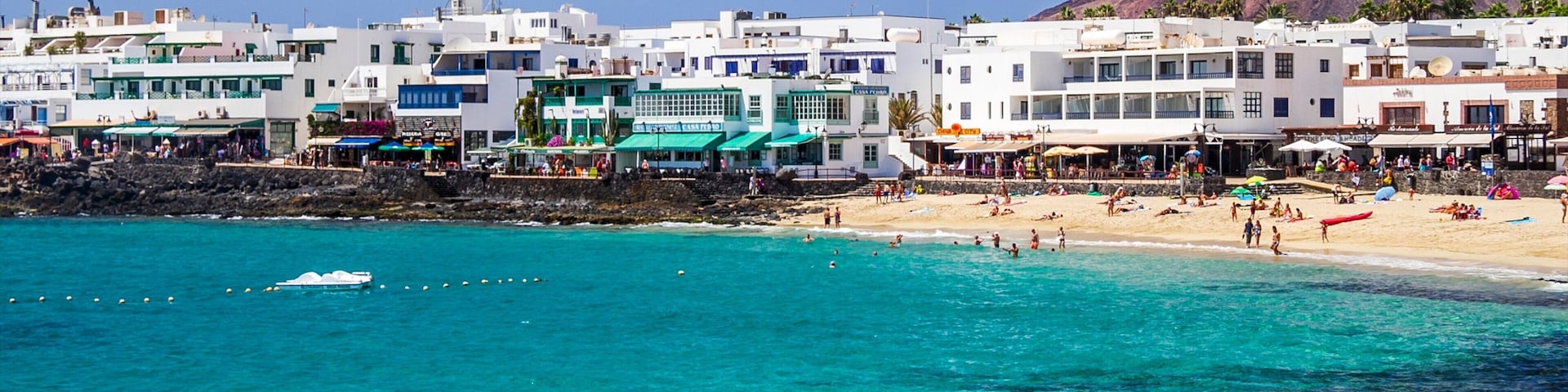 Lanzarote showing a coastal town, a sandy beach and a luxury hotel or resort