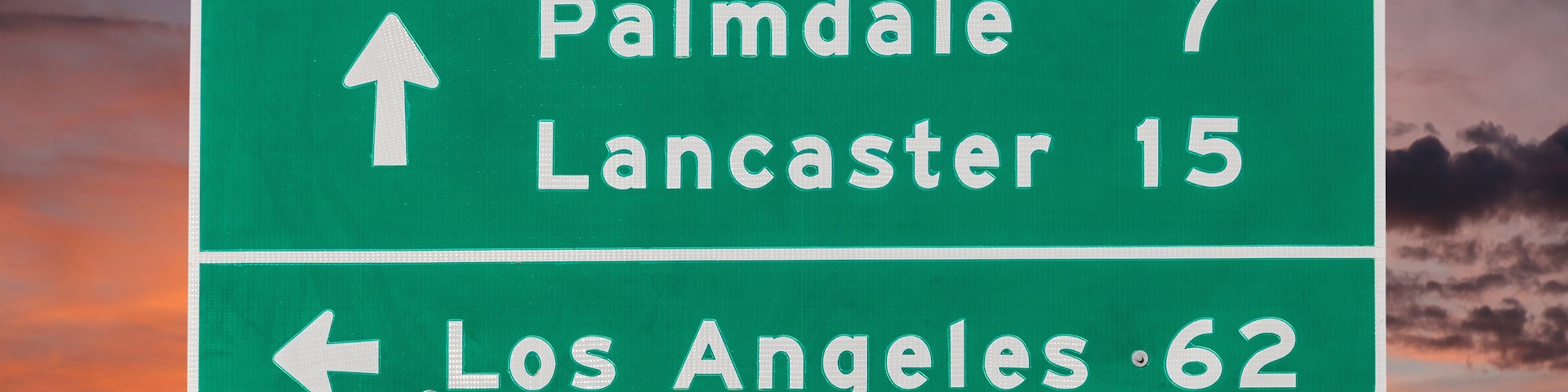 Palmdale, Lancaster and Los Angeles Highway Sign with Sunset Sky