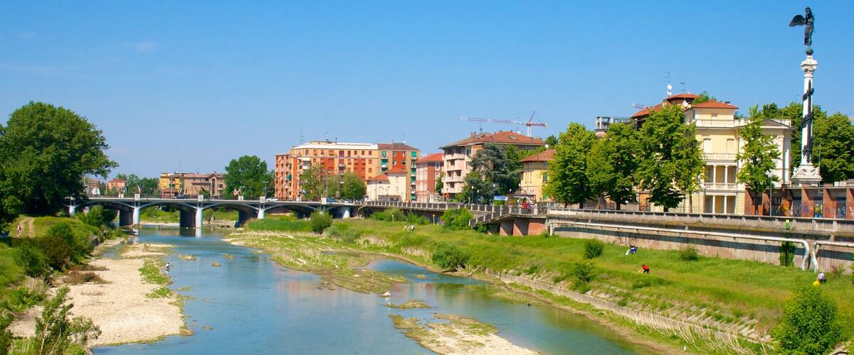 A river with a bridge, buildings, and a statue.