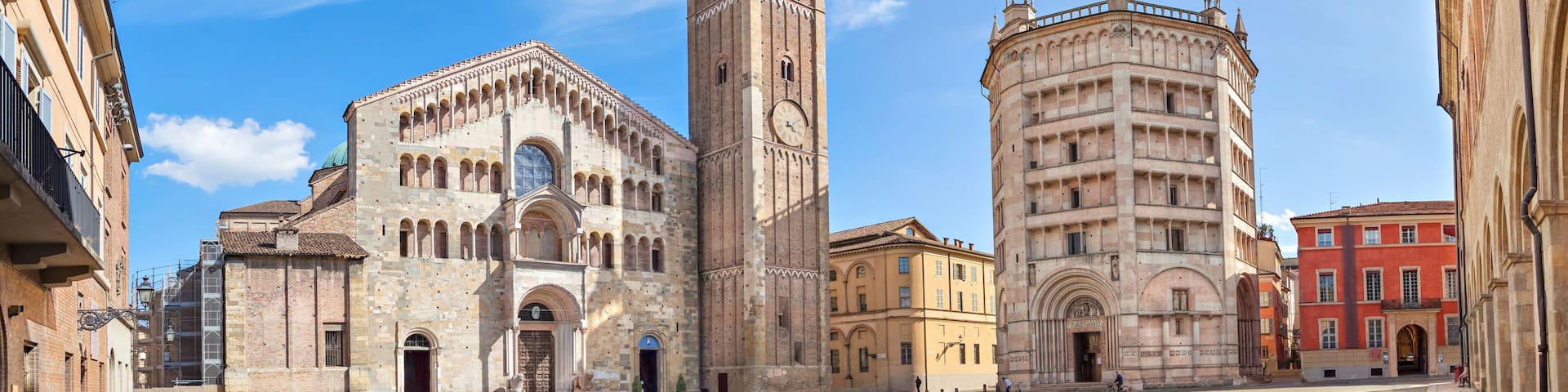 A historic square with a prominent church, a tall bell tower, and a round building with a dome.