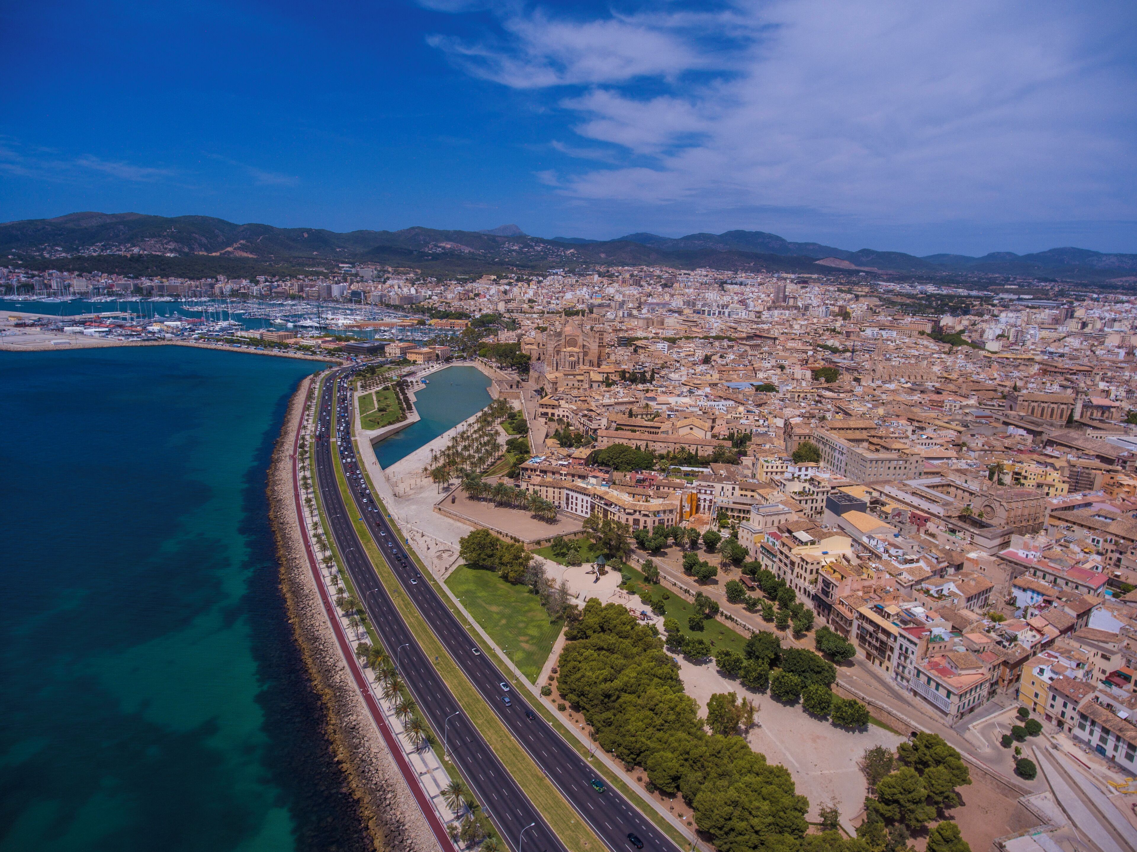 A coastal city with a marina, a long beachfront promenade, and dense urban buildings.
