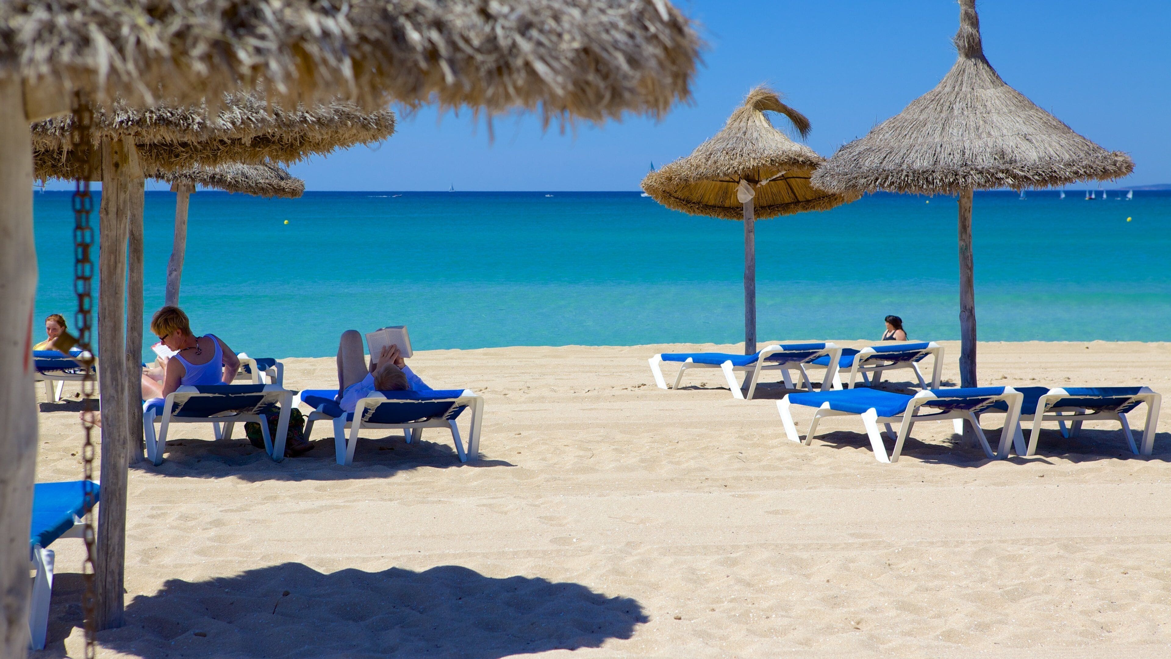 Palma de Mallorca mostrando una playa y un hotel o resort de lujo y también un pequeño grupo de personas