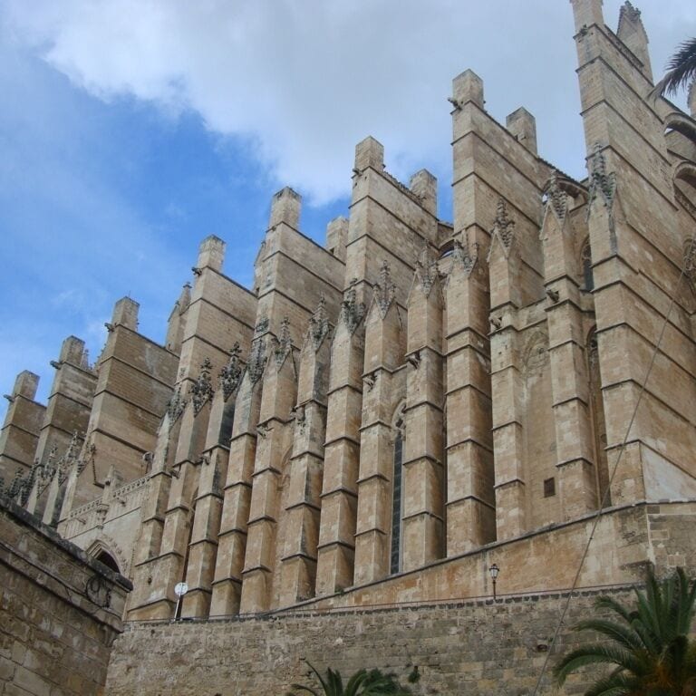 A historic stone building with multiple towers and arched windows.