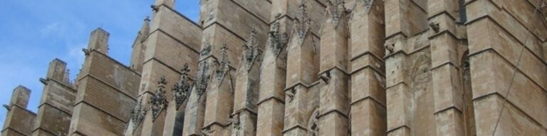 Un edificio histórico de piedra con múltiples torres y ventanas de arco.
