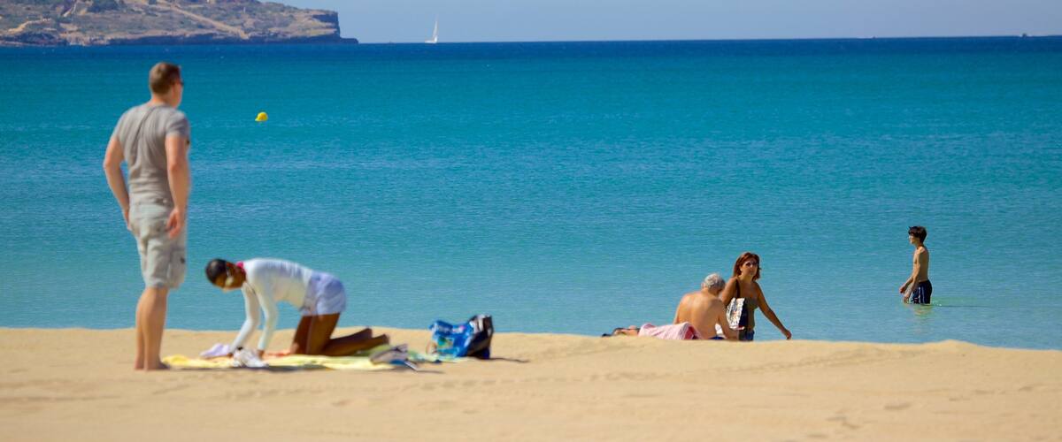 Palma de Mallorca showing a sandy beach as well as a small group of people