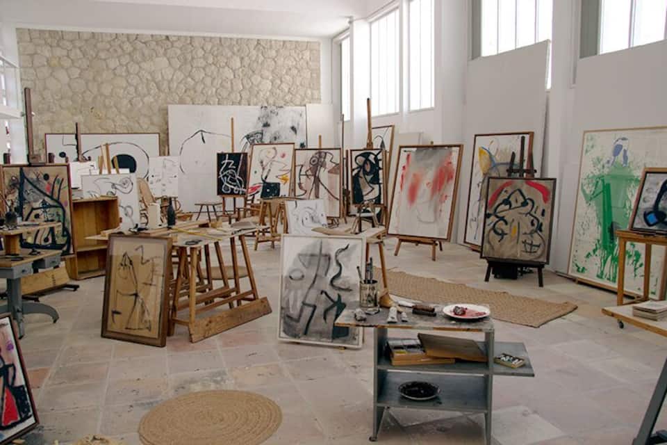 An art studio with easels, canvases, and art supplies.