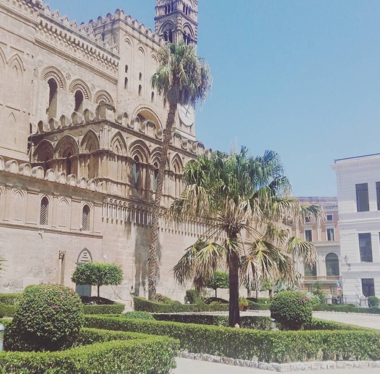 Um edifício histórico com janelas em arco e uma torre do relógio.