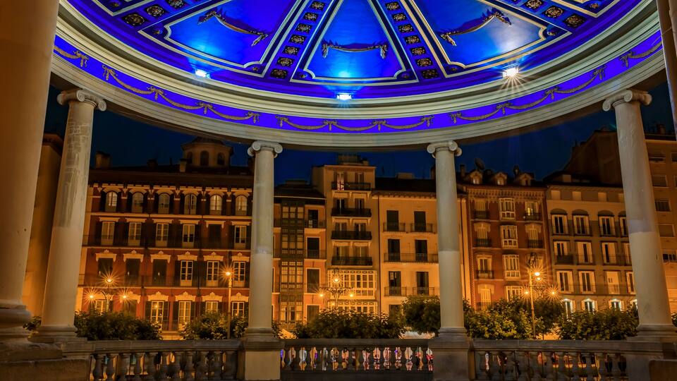 A grand building with a blue-lit dome and classical columns.