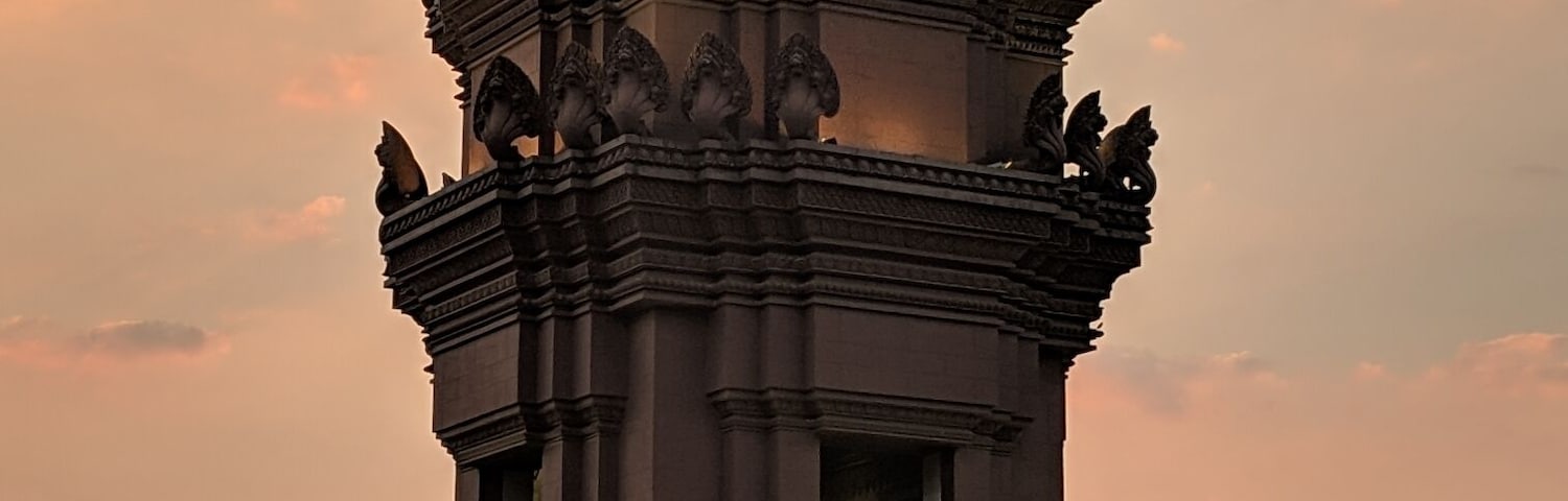 Um templo com esculturas detalhadas e uma fonte à frente.