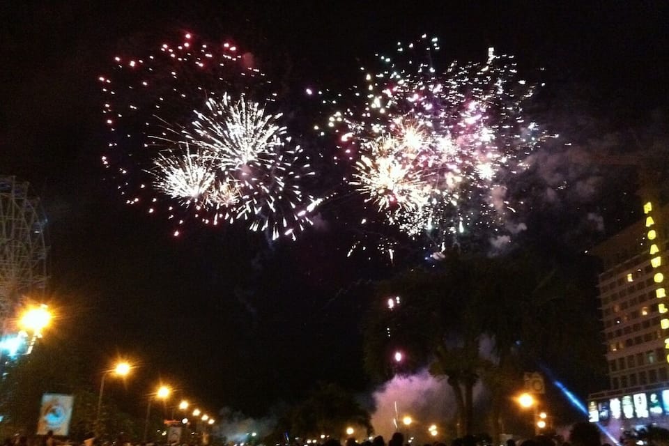Fuegos artificiales sobre un paisaje urbano nocturno.
