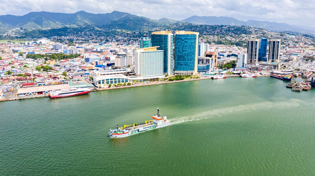 Aerial view of city of Port of Spain, the capital city of Trinidad and Tobago. Skyscrapers of the downtown and a busy sea port with commercial docks and passenger catamarans