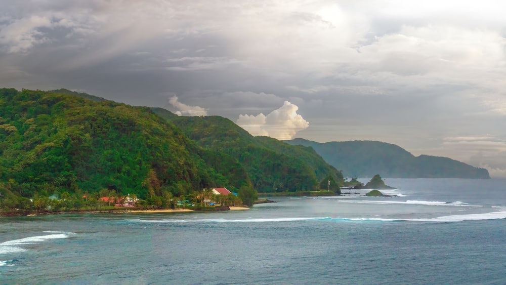 Scenic view of the coastline of Tutuila island, north of Pago Pago harbor, American Samoa, South Pacific, The famous camel rock can be seen in the distance