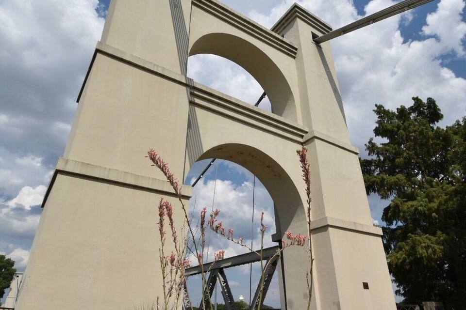 A large, beige, arched bridge structure with a metal framework.