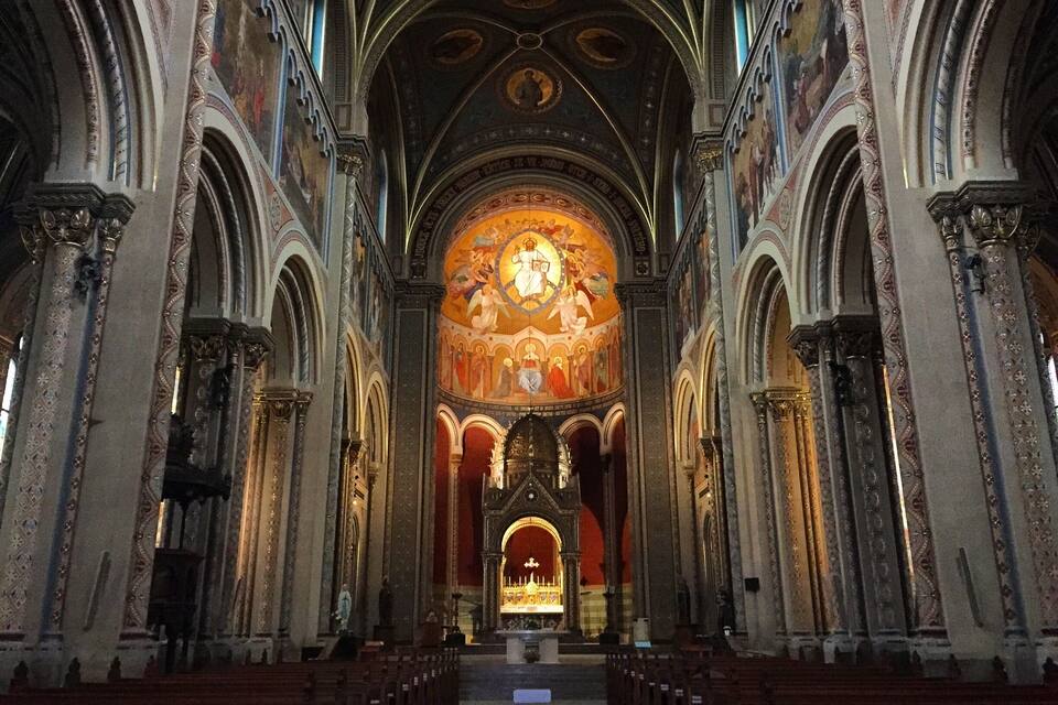 Interior d'una església ornamentada amb alts sostres volta i frescos detallats, i un altar central.