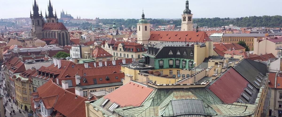 View of Old Town Prague from atop the Powder Tower with Prague Castle in the distance.