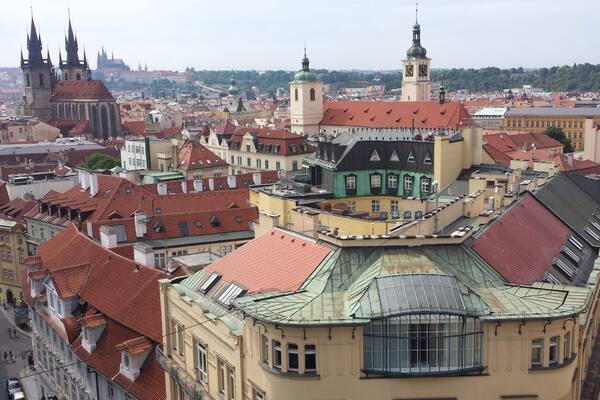 View of Old Town Prague from atop the Powder Tower with Prague Castle in the distance.