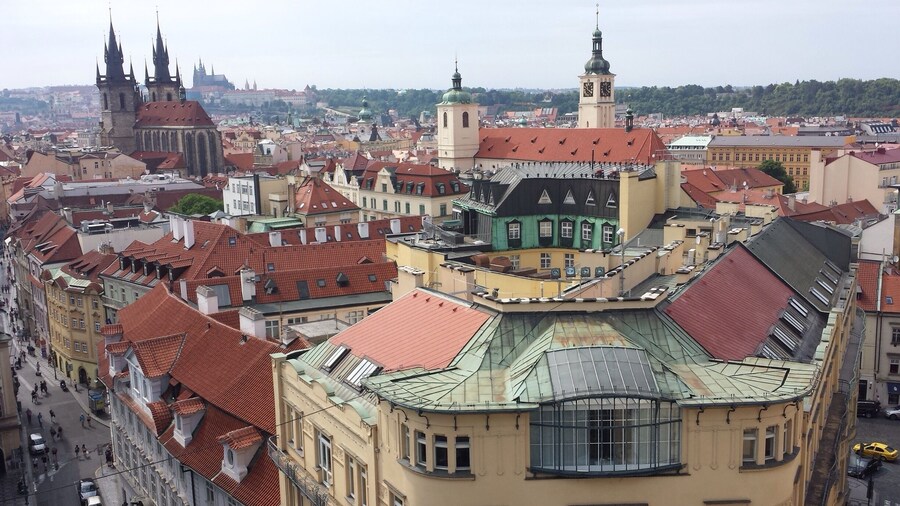 View of Old Town Prague from atop the Powder Tower with Prague Castle in the distance.
