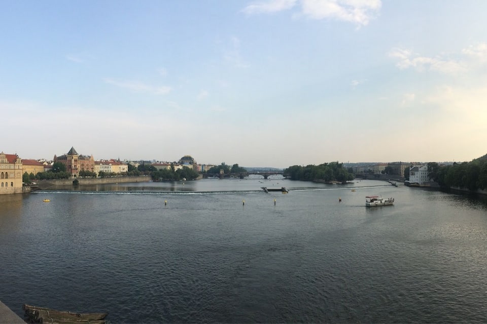 A river with boats, a bridge, and historic buildings along the banks.