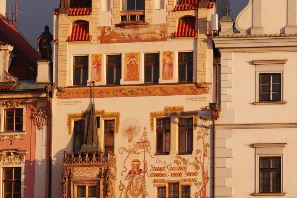 A historic building with ornate facades, red-tiled roofs, and detailed murals.