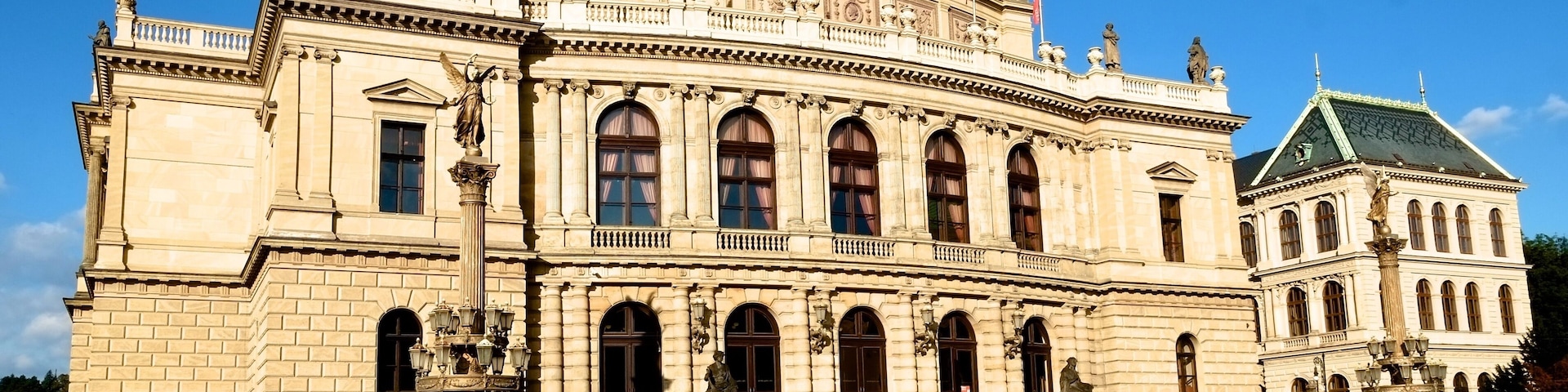 Rudolfinum is located on the right bank of the Vltava river at the Mánes Bridge on Aleš Embankment. This neo-Renaissance building was built by the Czech Savings Bank for the occasion of the 50th anniversary of its foundation. It was named after the Rudolfinum successor to the Habsburg throne, Archduke Rudolph. The architects hired for this project were the prominent personas of the art scene at the time - Josef Zítek and Josef Schulz.
The building was inaugurated in 1885 as a multipurpose cultural center with a concert hall and exhibition halls. Today, there is the Dvořák's Concert Hall, and also two smaller concert halls: Suk Hall and Kubelík Hall. The last complete renovation that the building has undergone was between 1990 and 1992.
Rudolfinum now houses the Czech Philharmonic orchestra and the Gallery Rudolfinum. Dvořák's Hall regularly hosts major concerts such as the world-famous Prague Spring