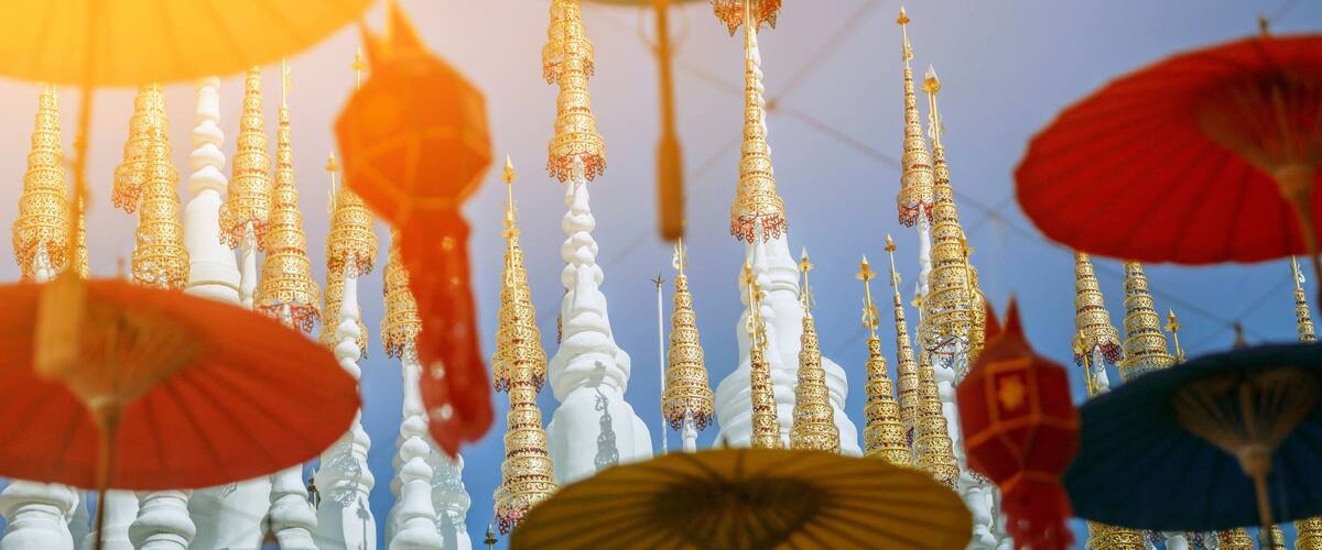 A collection of ornate, multi-tiered white and gold structures with intricate designs, possibly part of a temple or historical site.