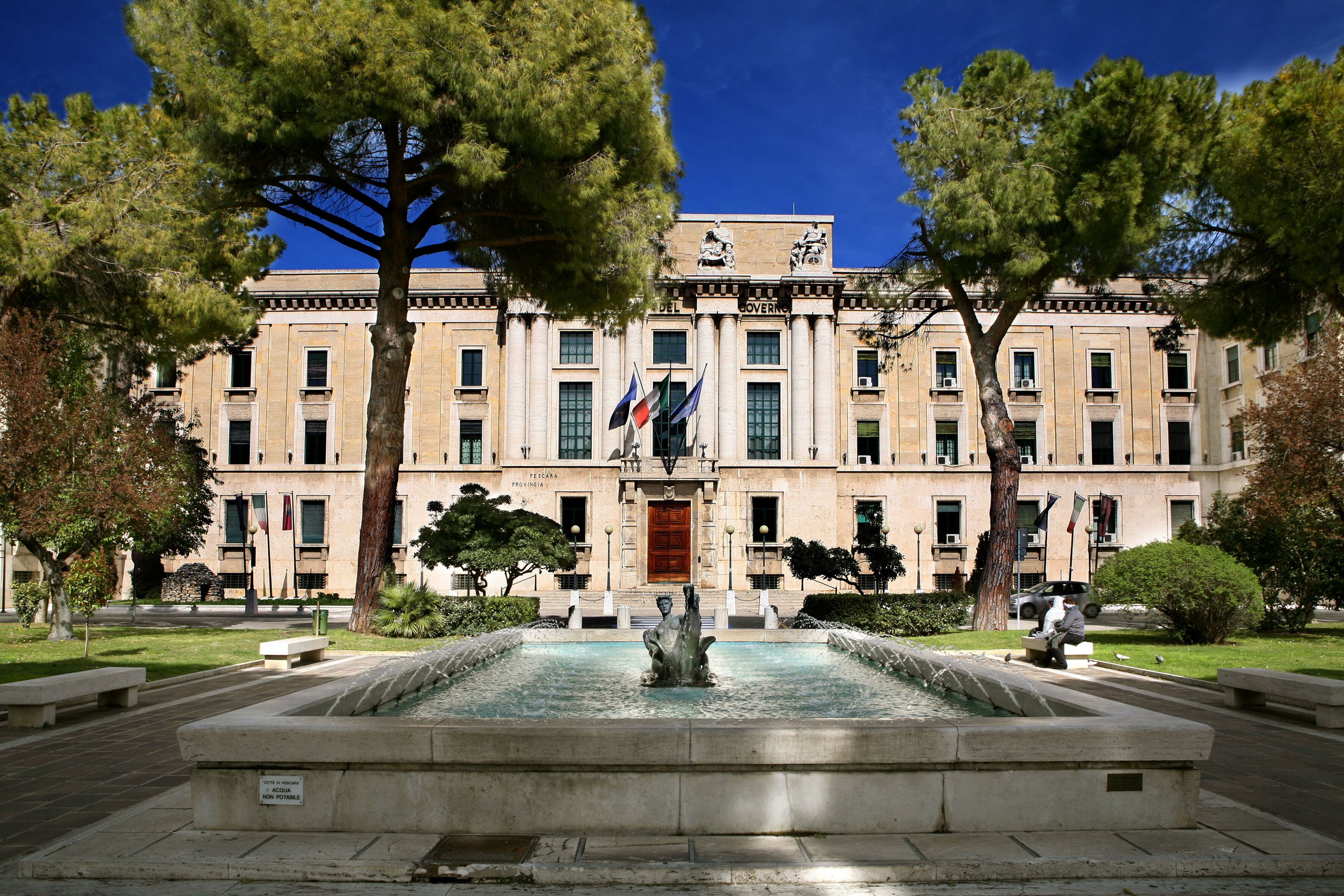 A government building with a fountain in front.