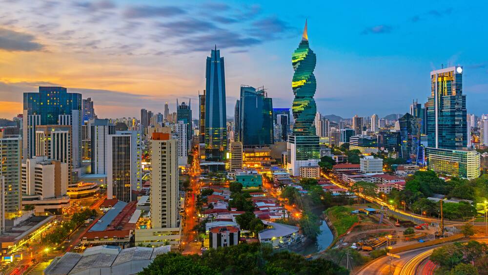 Un paysage urbain avec des gratte-ciel modernes, une tour à l’architecture originale et une rivière qui traverse le centre-ville.