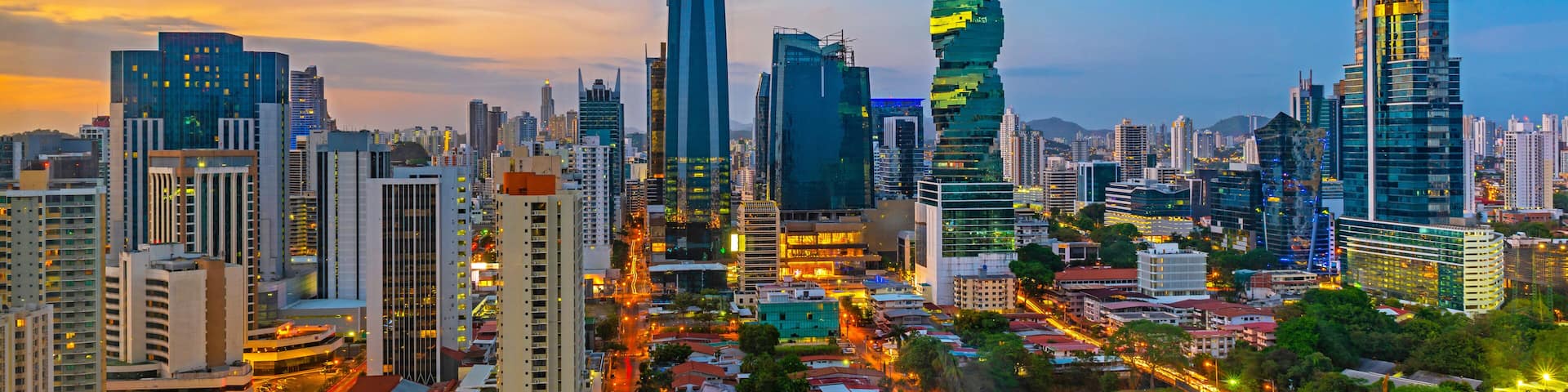 A cityscape with modern skyscrapers, a twisting tower, and a river running through the center.