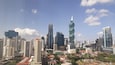 A cityscape with modern skyscrapers, including a distinctive twisting tower.