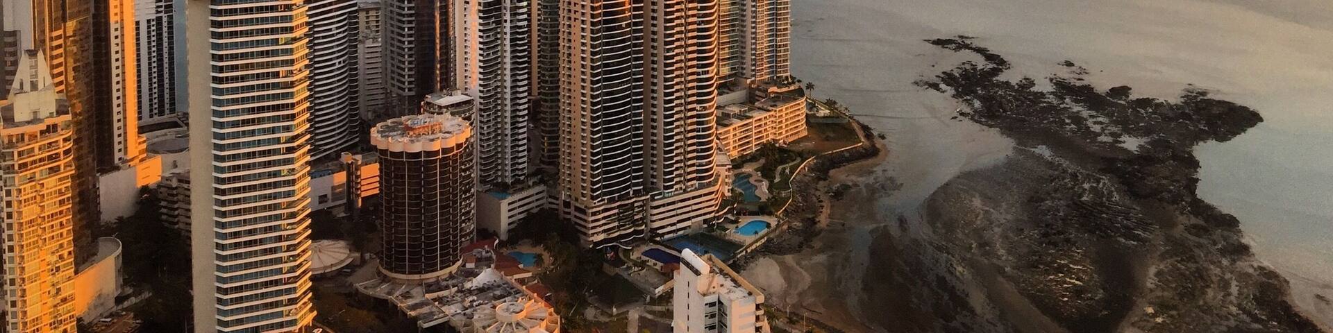 A coastal cityscape with high-rise buildings and a beach.