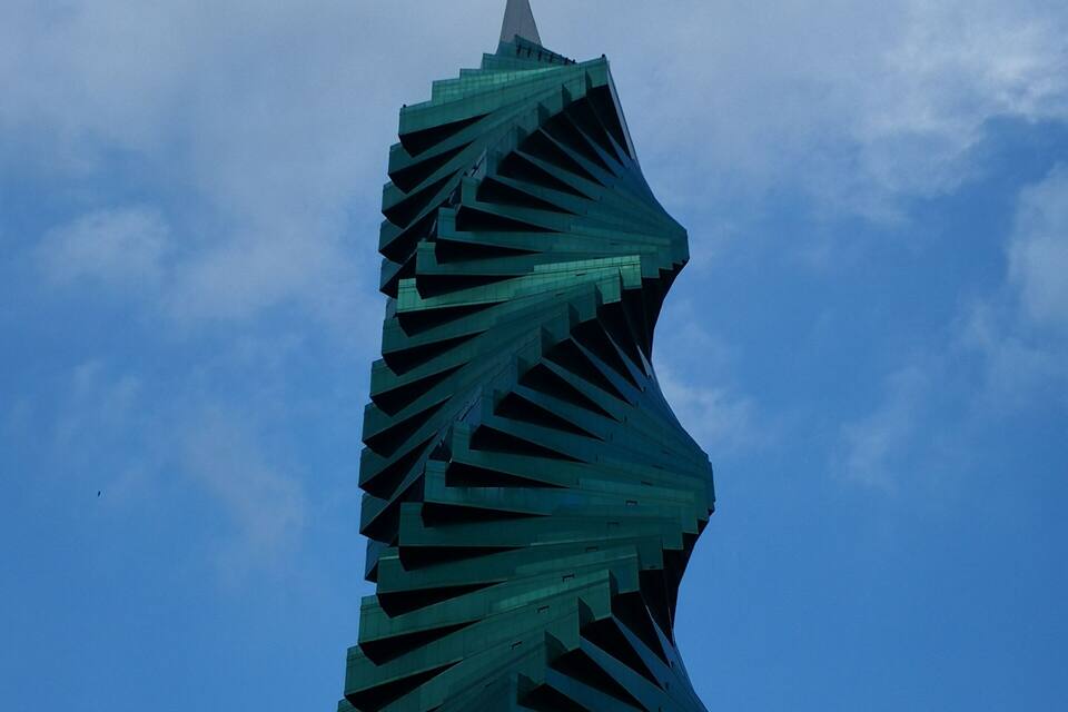 A spiraling skyscraper against a clear blue sky.