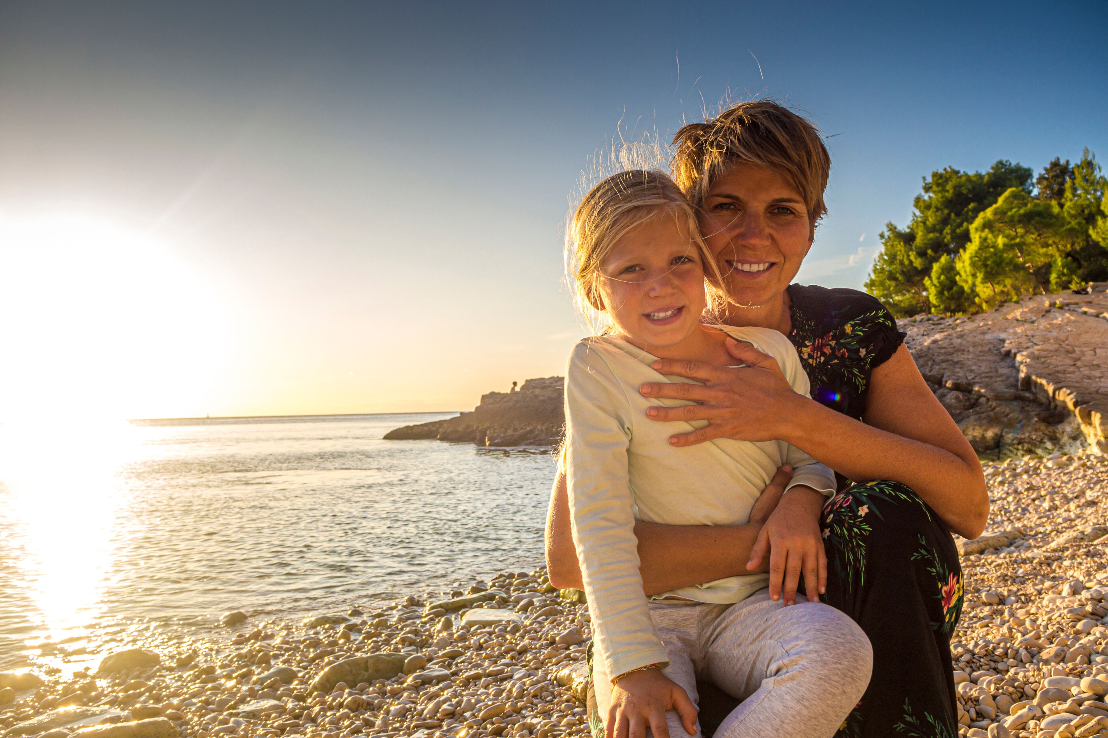 Croatia, Istria, Pula, Cape Kamenjak, blonde girl with mother, sunset scene