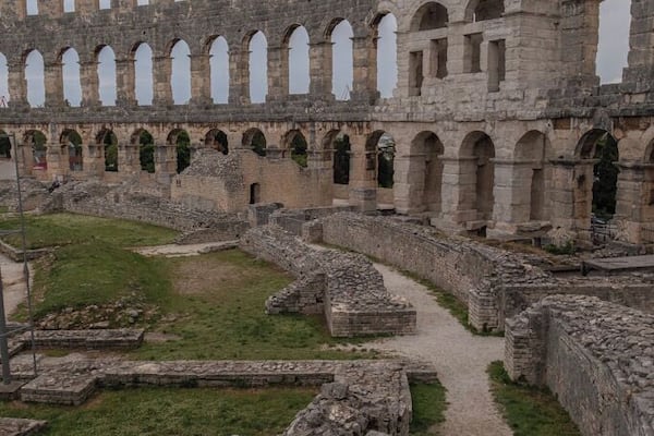 The most famous and important monument, the starting and ending point of every sightseeing tour is the Amphitheater, popularly called the Arena of Pula, which was once the site of gladiator fights. It was built in the 1st century AD during the reign of Emperor Vespasian, at the same time as the magnificent Colosseum in Rome.
The ground plan is elliptical, the longer axis measuring about 130 m and the shorter one about 100 m. Gladiator fights took place in the central flat area called the arena, while the spectators could sit on the stone tiers or stand in the gallery. It is believed that the Amphitheater could seat about 20,000 spectators. Local limestone was used for its construction. In the Middle Ages it was the site of knights tournaments and fairs.