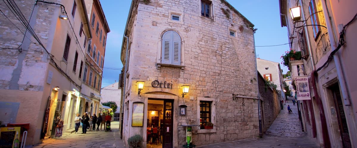 A narrow cobblestone street with historic stone buildings, a café named "Orte", and a sign for "Galeria".
