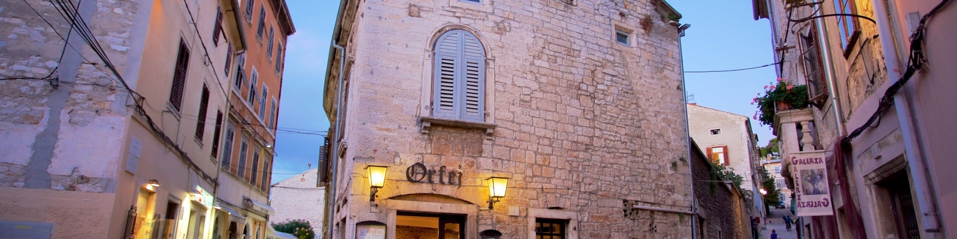 A narrow cobblestone street with historic stone buildings, a café named "Orte", and a sign for "Galeria".