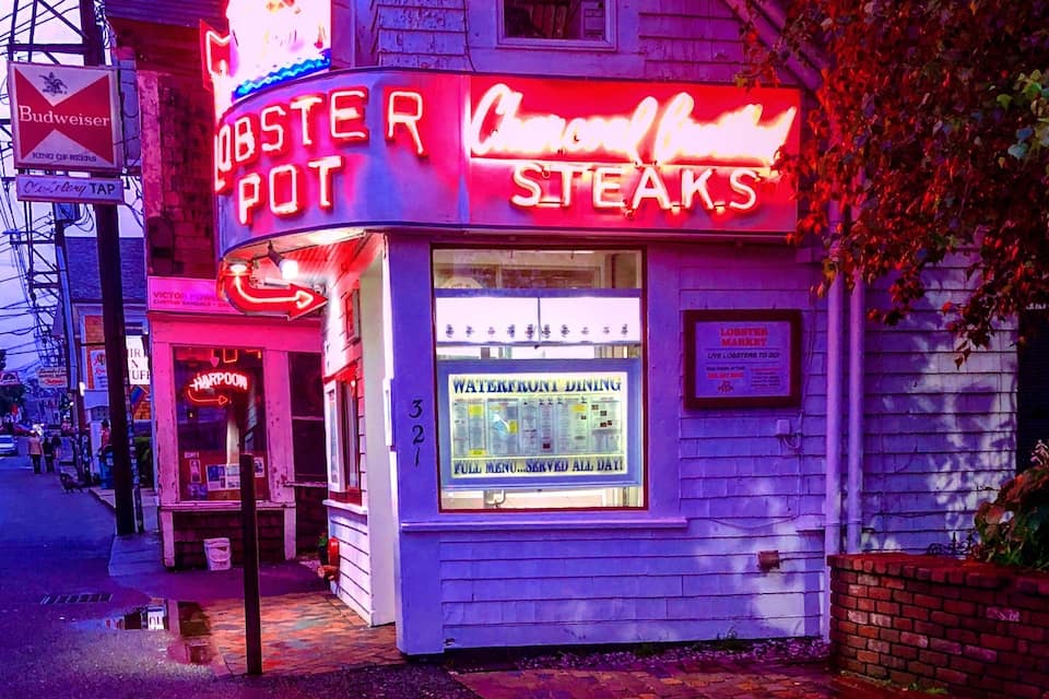 Neonvaloin koristeltu liike, jonka yläpuolella on kyltti, jossa lukee: «Lobster Pot» ja «Steaks».
