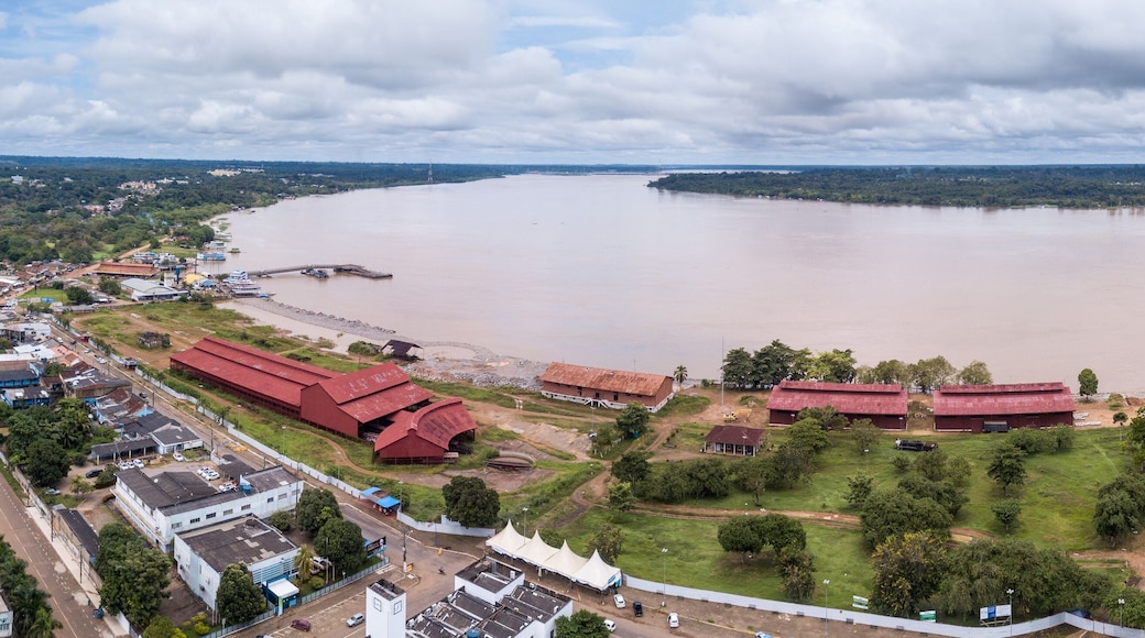 Aerial drone view of Madeira river, Porto Velho city center streets with "Museu da Estrada de Ferro Madeira-Mamore" and Amazon rainforest in the background on cloudy winter day. Rondonia, Brazil.