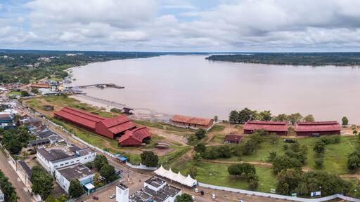 Aerial drone view of Madeira river, Porto Velho city center streets with "Museu da Estrada de Ferro Madeira-Mamore" and Amazon rainforest in the background on cloudy winter day. Rondonia, Brazil.