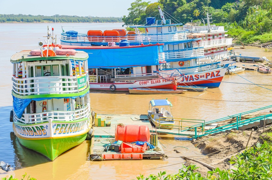 PORTO VELHO, BRAZIL - JUNE 16, 2017: Tour boats on the banks of the Madeira River. Boats departs from Estrada de Ferro Madeira-Mamore carrying many tourists with some onboard food services.