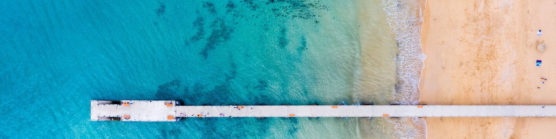 Aerial top view of Porto Santo island old pier, Porto Santo, Madeira, Portugal