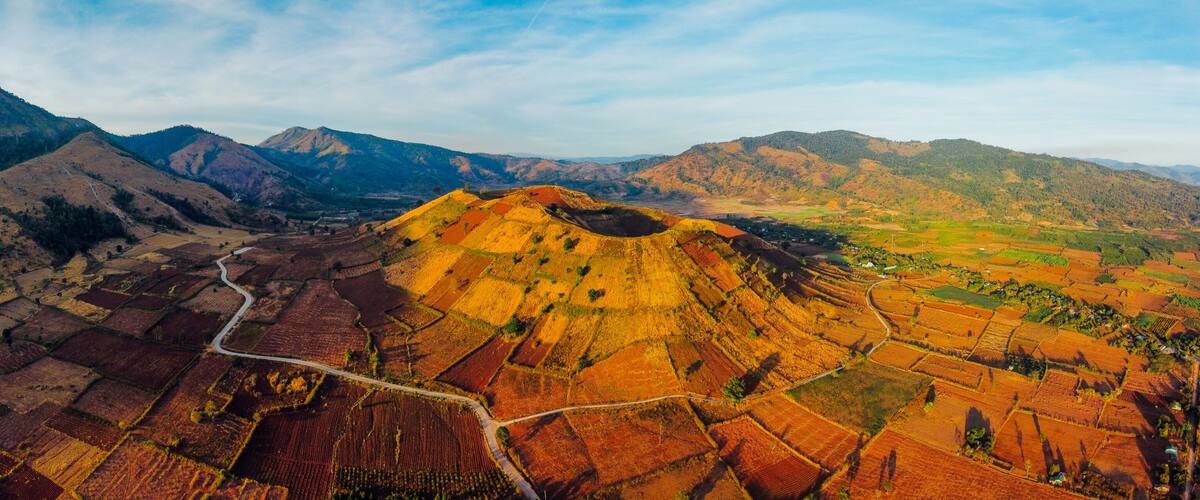 A mountainous landscape with terraced fields and a winding road.