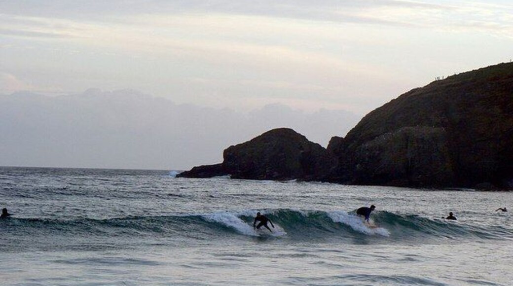 Hoe Point. Seen from the beach near Sydney Cove at Praa Sands. With late evening surfers.